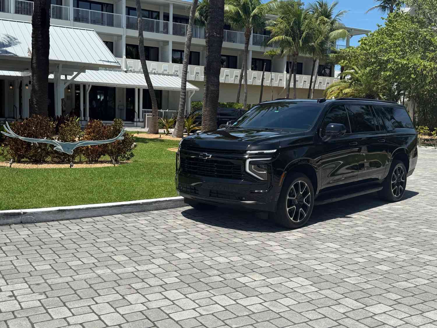 Luxury SUV parked beside a private plane for Florida Keys airport transportation